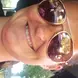 Amanda Collins wearing sunglasses and a pink shirt smiling