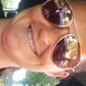 Amanda Collins wearing sunglasses and a pink shirt smiling