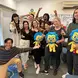 group of students standing in front of a whiteboard holding plushies