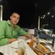 Dimitrios smiling at the camera while enjoying his evening meal