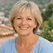 Blonde woman in a blue shirt smiling at the camera