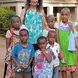 Our volunteer posing with some children from a children's home after donating hand made clothes from our sawing project