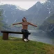 Girl in rainbow striped top poses in front of backdrop of the Norwegian Fjords