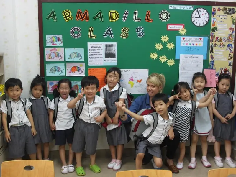 group of children in uniforms in front of board