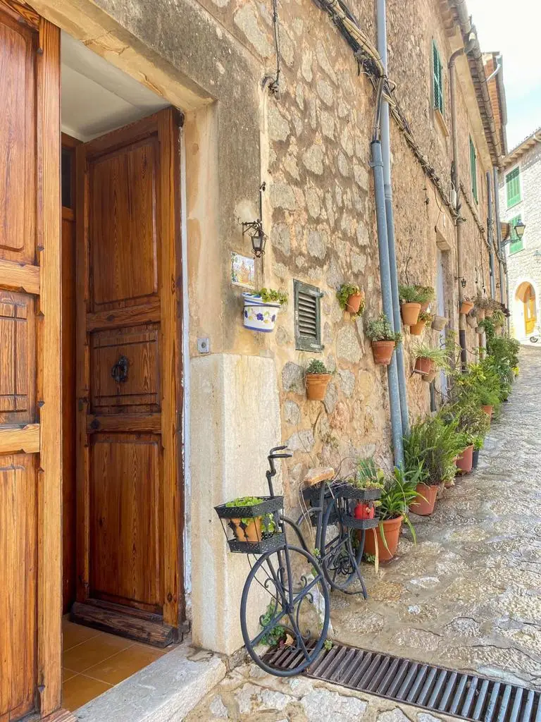A quaint alleyway featuring a vintage bicycle leaning against a weathered door, capturing the essence of Spain and RVF International’s teach abroad adventure.