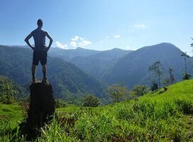 person standing on top of a tall rock