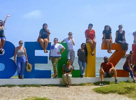 people around a Belize Sign
