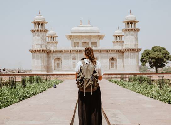 Young woman's back in front of historic Indian building