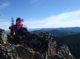 girl on mountaintop overlooking view of mountains in Montana