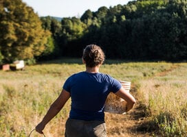 Intern at Work carrying a bucket of water on a farm