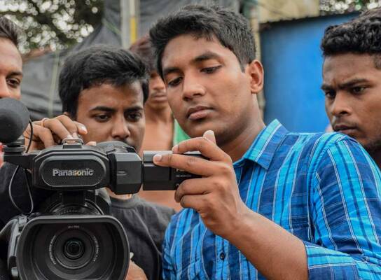 Young men using video camera