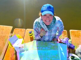 Female gap year participant smiling with a map and compass.