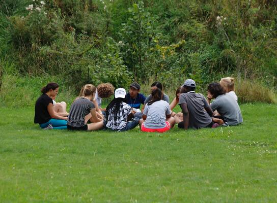 Participants in a circle outdoors 