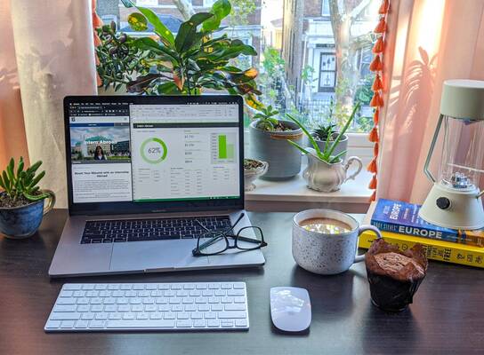 A desk with a laptop, glasses, and coffee - all ready for a day at your virtual internship!