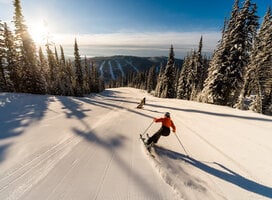 Skier on morning run, empty slopes