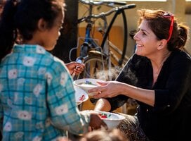 Volunteer helping with breakfast programme at community project in Cambodia
