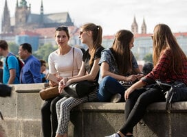 Students sit on a stone wall