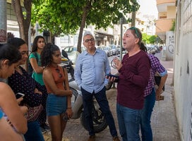 A professor explains a concept to students while on a tour of Tel Aviv