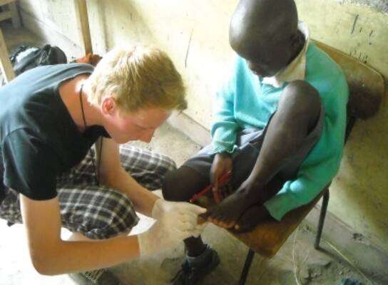 a medical volunteer removing jiggers in one of the students