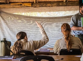 A Bushwise student raises her hand to ask a question during a lecture.