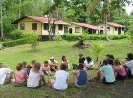Students sitting in a circle on the grass at a field research station
