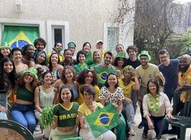 Students, faculty, and staff posing for a photo during a World Cup 2022 watch party