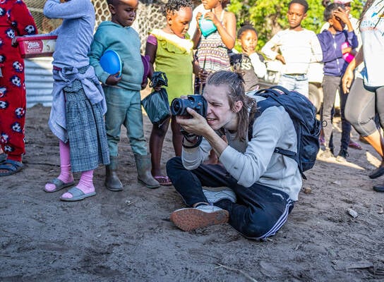 Impact Photography volunteer with community children