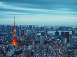 Panorama image a metropolis skyline with numerous high rises visible dwarfed by a tall red and white tower