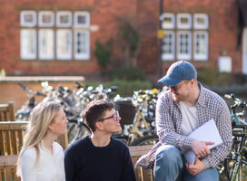 students talk on a bench