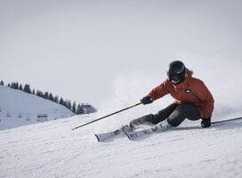 Woman skiing down a groomed piste