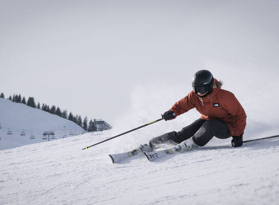 Woman skiing down a groomed piste