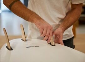 Young man working on a composite surfboard he built at IYRS.