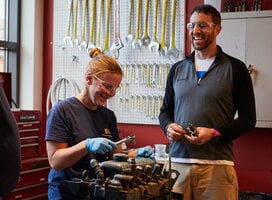 Young woman working on a diesel engine.