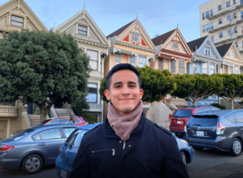 Young man poses in front of Painted Ladies in San Francisco