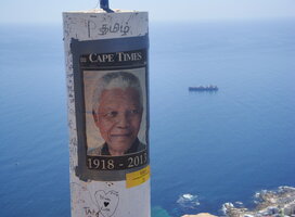 A poster of Nelson Mandela, the ocean in the background 