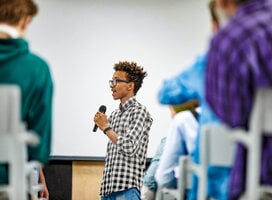 A student speaking through a microphone