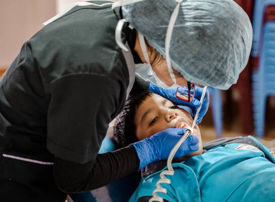 Medical professional provides child with dental service