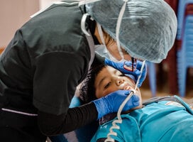Medical professional provides child with dental service