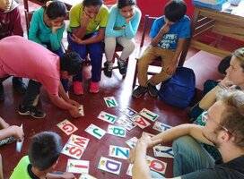 Children sitting in classroom studying letters in English