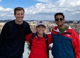 Students posing on overlook above city of Rome