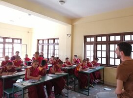 The monks are in the class room and our volunteer are teaching to the monks in the Buddhist Monaster.
