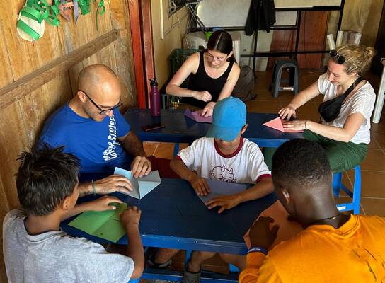 people sitting around table doing a craft