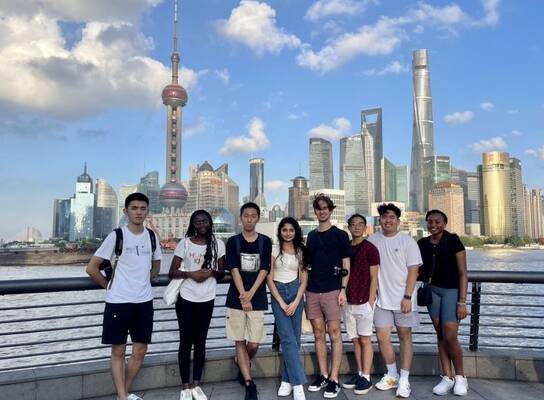 Students posing with Shanghai skyline behind them 