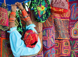 Panamanian woman hanging colorful textiles on a clothes line