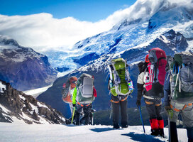 NOLS students crest the top of a mountain pass