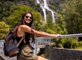 Woman smiling near waterfall