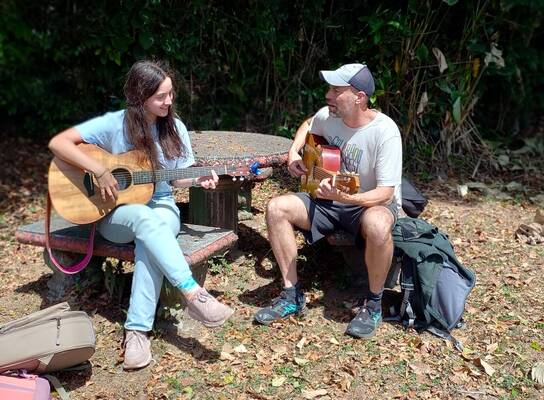 Intern playing guitar with our music teacher