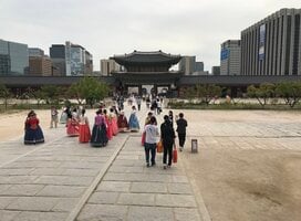 People in traditional dress in front of a temple