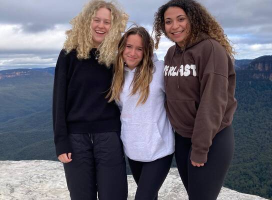 Three students on a mountaintop in Australia