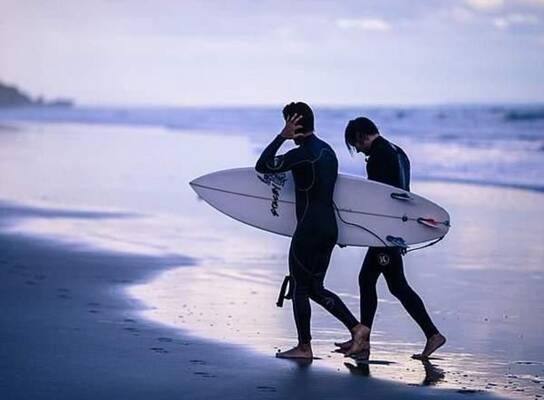 two surfers walking